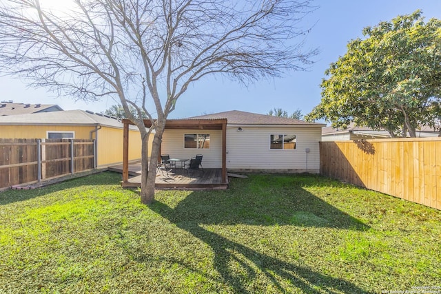 rear view of house featuring a wooden deck and a yard