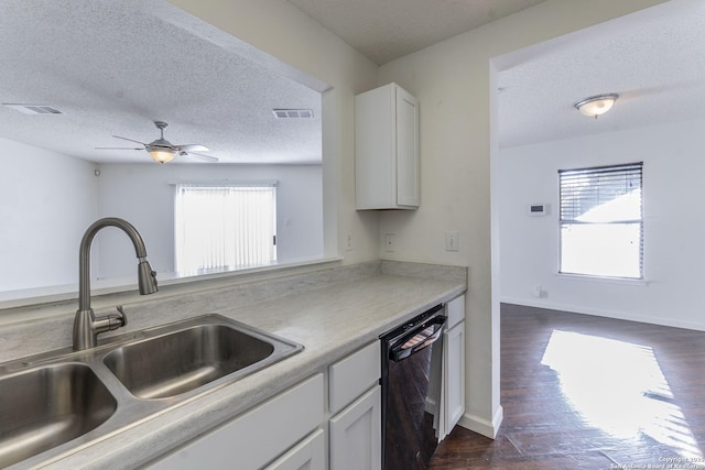 kitchen featuring dark hardwood / wood-style floors, black dishwasher, sink, white cabinets, and a textured ceiling