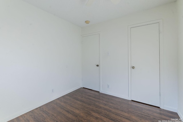 unfurnished bedroom with dark hardwood / wood-style floors and ceiling fan