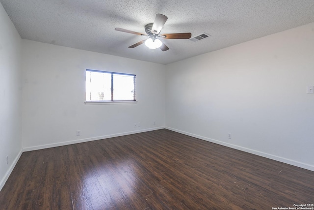 empty room featuring dark hardwood / wood-style flooring, a textured ceiling, and ceiling fan