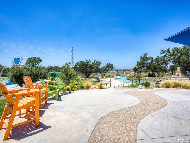 view of community with a swimming pool and a patio area