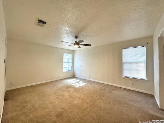 carpeted spare room featuring ceiling fan and a textured ceiling