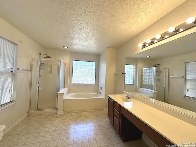 bathroom with vanity, separate shower and tub, and a textured ceiling