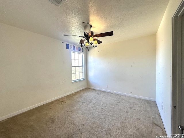 carpeted empty room with ceiling fan and a textured ceiling