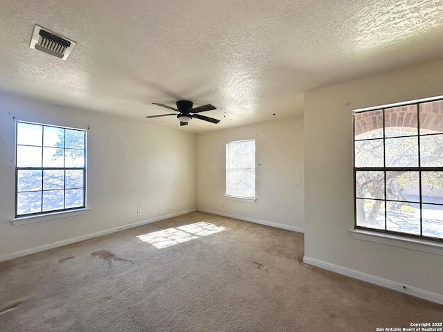 carpeted spare room with a textured ceiling and ceiling fan