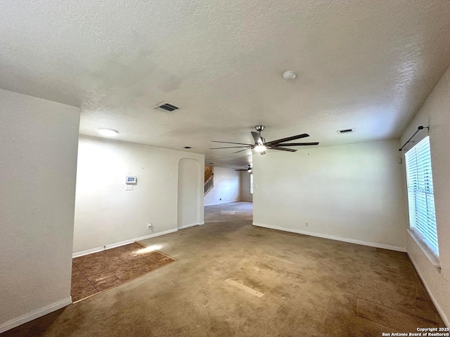 spare room with ceiling fan, a textured ceiling, and carpet