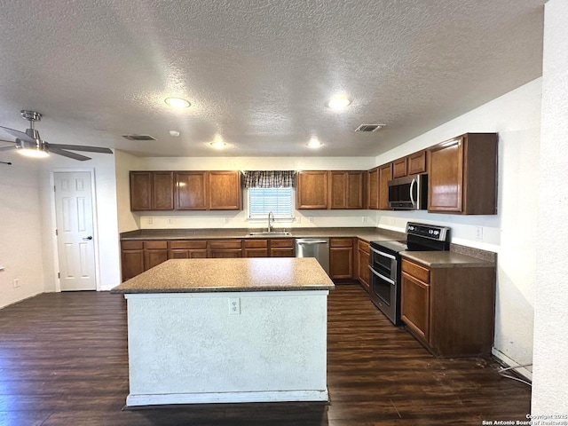 kitchen featuring sink, dark wood-type flooring, stainless steel appliances, and a kitchen island