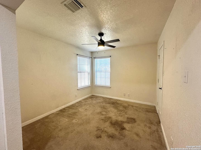 empty room featuring a textured ceiling, carpet floors, and ceiling fan