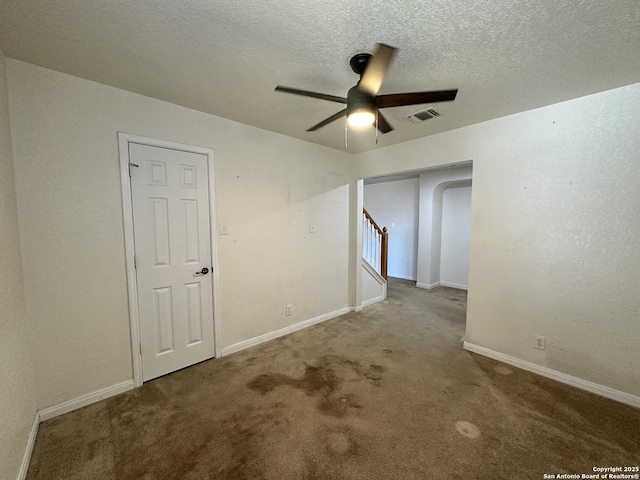 spare room featuring ceiling fan, carpet flooring, and a textured ceiling