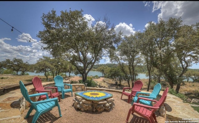 view of patio / terrace featuring an outdoor fire pit and a water view