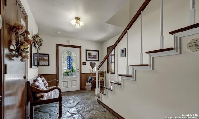 foyer entrance with wooden walls