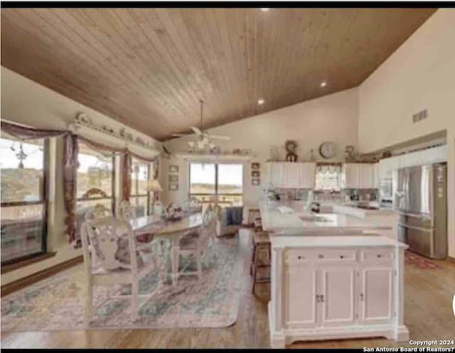 kitchen with ceiling fan, stainless steel refrigerator with ice dispenser, white cabinets, vaulted ceiling, and wooden ceiling