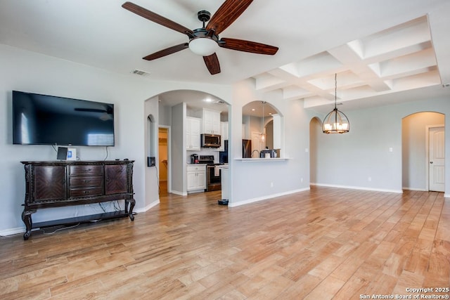 living room with coffered ceiling, beam ceiling, light hardwood / wood-style flooring, and ceiling fan with notable chandelier