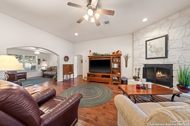 living room with ceiling fan, a fireplace, and dark hardwood / wood-style floors