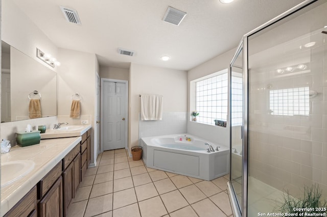 bathroom featuring tile patterned floors, vanity, independent shower and bath, and a textured ceiling