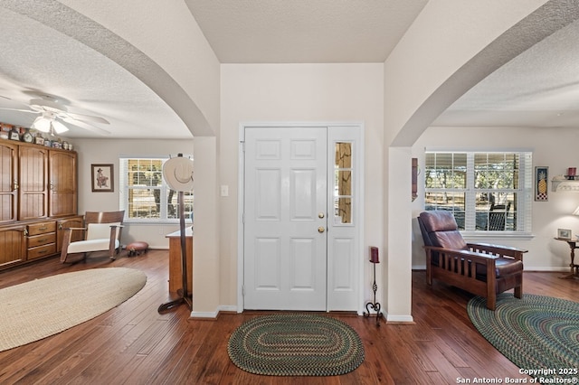 entrance foyer with dark hardwood / wood-style flooring, ceiling fan, and a textured ceiling