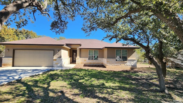 909 Marlys Ave, Canyon Lake, TX 78133 - view of front facade with stone siding, an attached garage, concrete driveway, and stucco siding