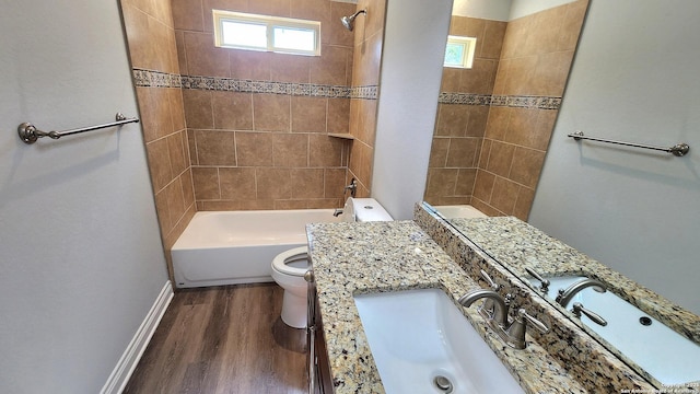 full bathroom with hardwood / wood-style flooring, plenty of natural light, toilet, and tiled shower / bath combo