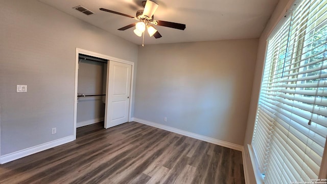 unfurnished bedroom with dark hardwood / wood-style flooring, a closet, and ceiling fan