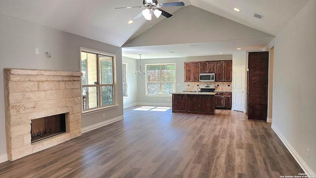 unfurnished living room with ceiling fan with notable chandelier, high vaulted ceiling, and hardwood / wood-style floors