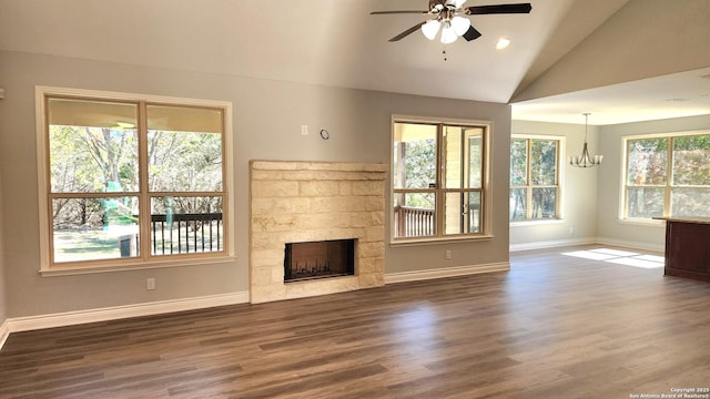 unfurnished living room with a tile fireplace, lofted ceiling, ceiling fan with notable chandelier, and dark hardwood / wood-style flooring