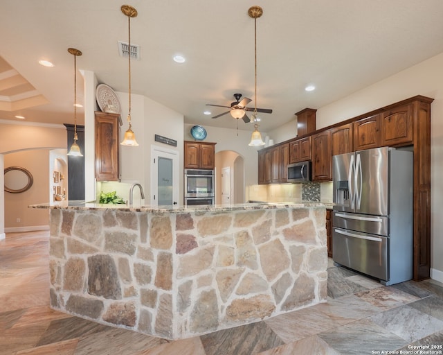 kitchen featuring visible vents, arched walkways, a ceiling fan, stainless steel appliances, and light stone counters