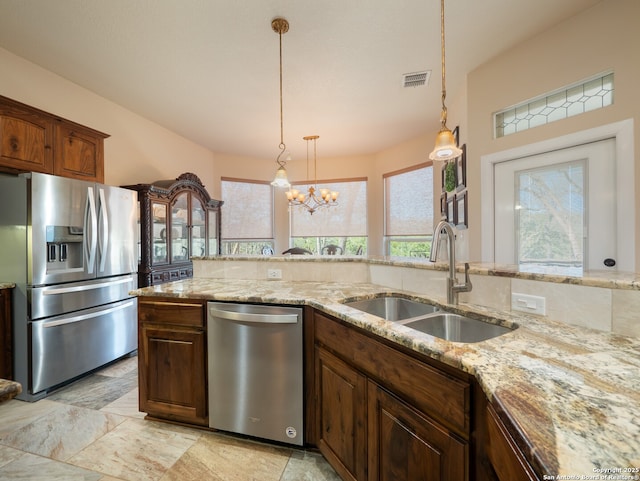 kitchen with visible vents, hanging light fixtures, an inviting chandelier, a sink, and appliances with stainless steel finishes