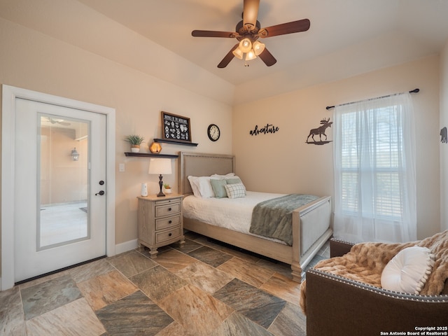bedroom featuring ceiling fan, baseboards, and stone finish flooring