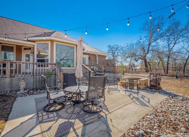 view of patio with an outdoor fire pit, outdoor dining space, and fence