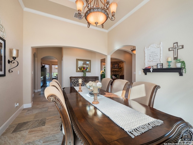 dining area featuring arched walkways, baseboards, ornamental molding, and visible vents