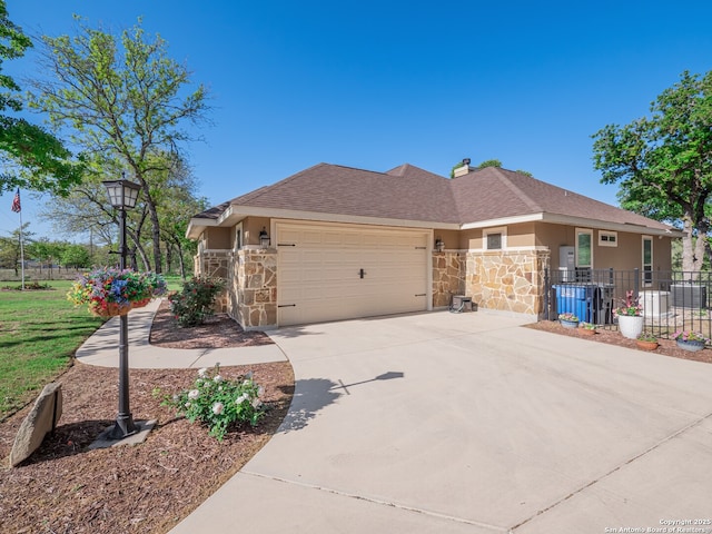 view of front of property featuring an attached garage, stone siding, fence, stucco siding, and driveway