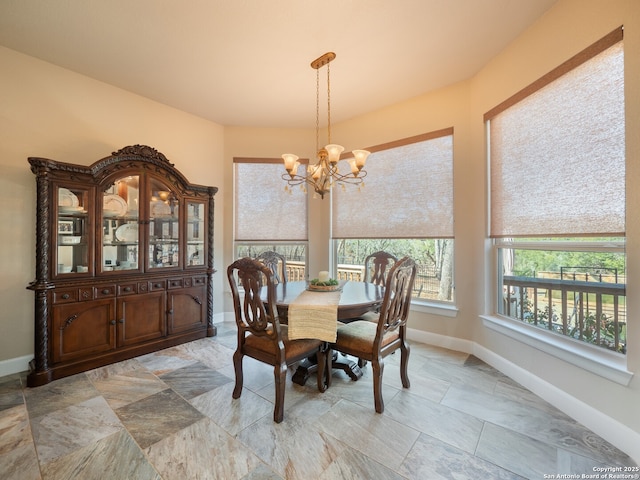 dining space featuring an inviting chandelier and baseboards