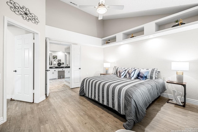 bedroom featuring lofted ceiling, connected bathroom, ceiling fan, and light hardwood / wood-style flooring