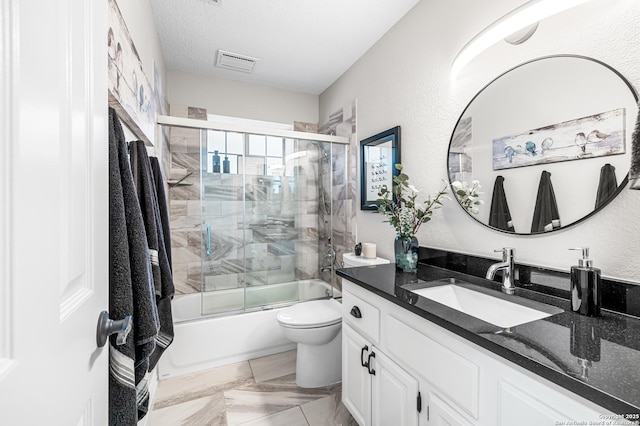 full bathroom featuring bath / shower combo with glass door, vanity, a textured ceiling, and toilet