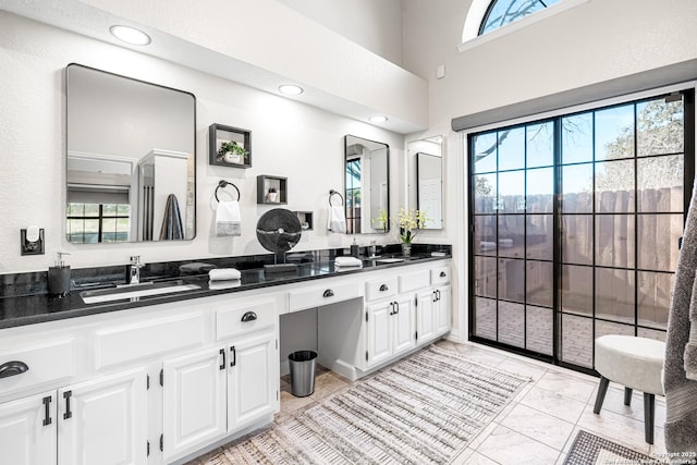 bathroom featuring a towering ceiling and vanity