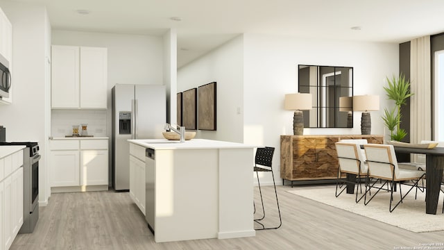 kitchen featuring appliances with stainless steel finishes, white cabinetry, a kitchen breakfast bar, a kitchen island, and light wood-type flooring