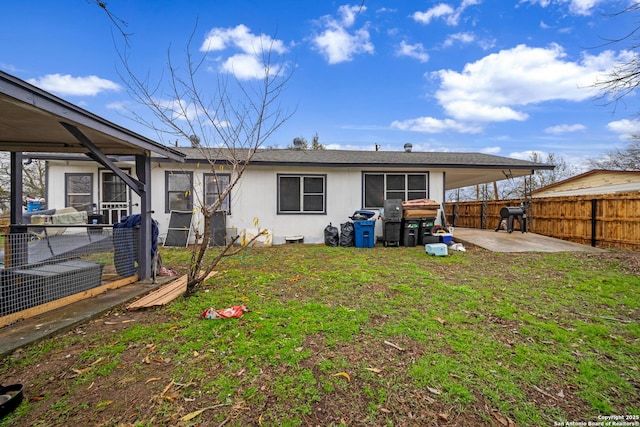 rear view of property with a yard and a patio