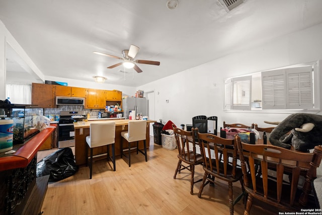 dining area with ceiling fan and light hardwood / wood-style floors