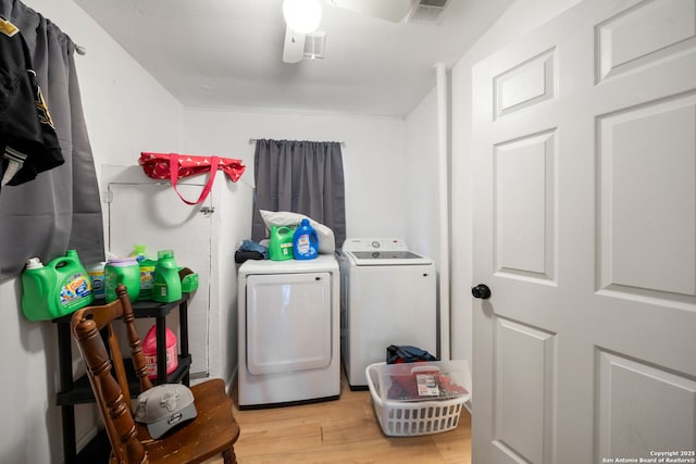 laundry area with washer and dryer and light hardwood / wood-style floors