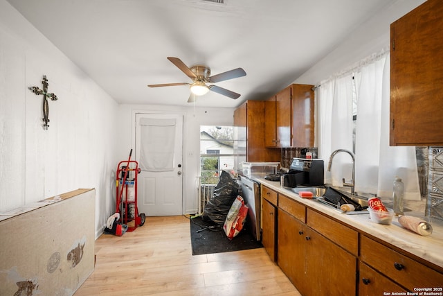 kitchen featuring sink, ceiling fan, dishwasher, and light wood-type flooring