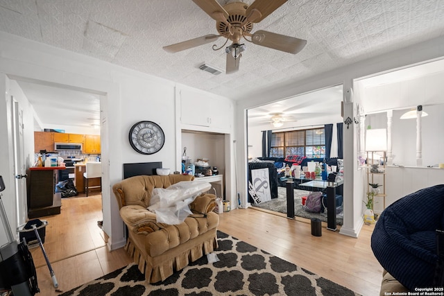 living room with ceiling fan and light wood-type flooring