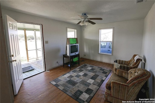 sitting room with dark hardwood / wood-style floors, a wealth of natural light, and a textured ceiling