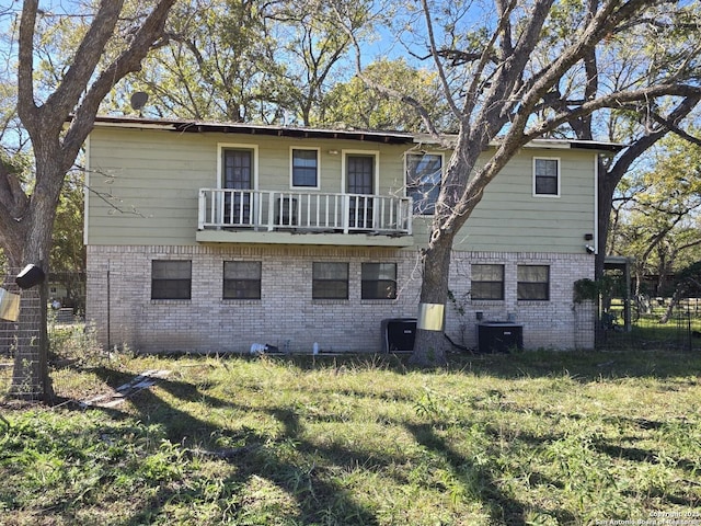 rear view of house with a yard and a balcony