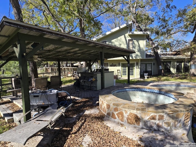 view of patio featuring exterior bar and an outdoor hot tub