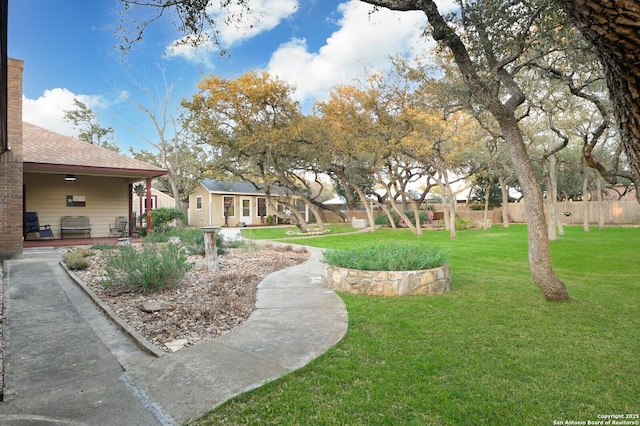 view of yard with an outbuilding, a patio area, and fence