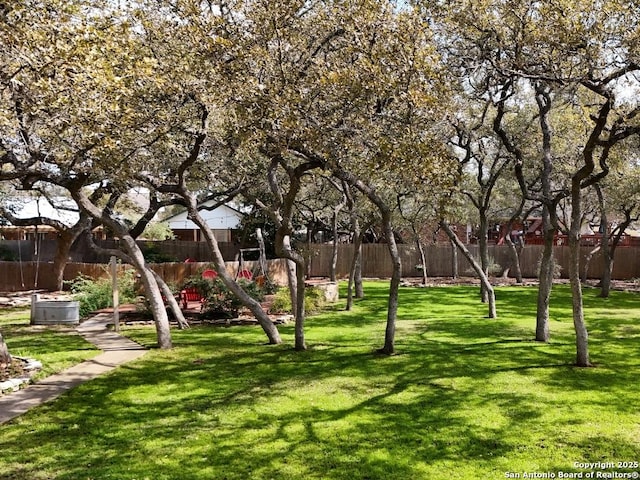 surrounding community featuring fence private yard, playground community, and a yard