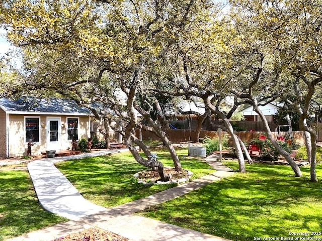 view of community with fence and a yard