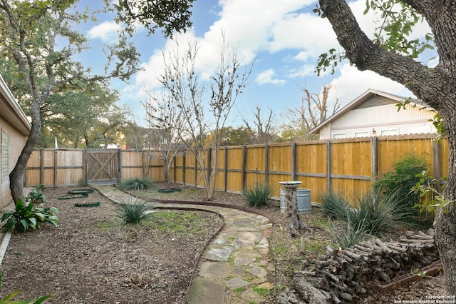 view of yard with a fenced backyard and a gate