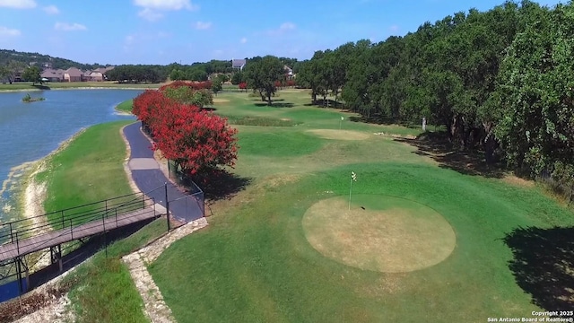 drone / aerial view featuring view of golf course and a water view