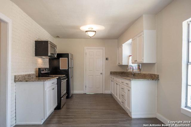 kitchen featuring light stone counters, sink, stainless steel appliances, and white cabinets